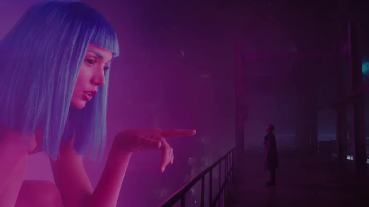 Source scene of a giant pink hologram with blue hair reaching toward a small person on a dark platform